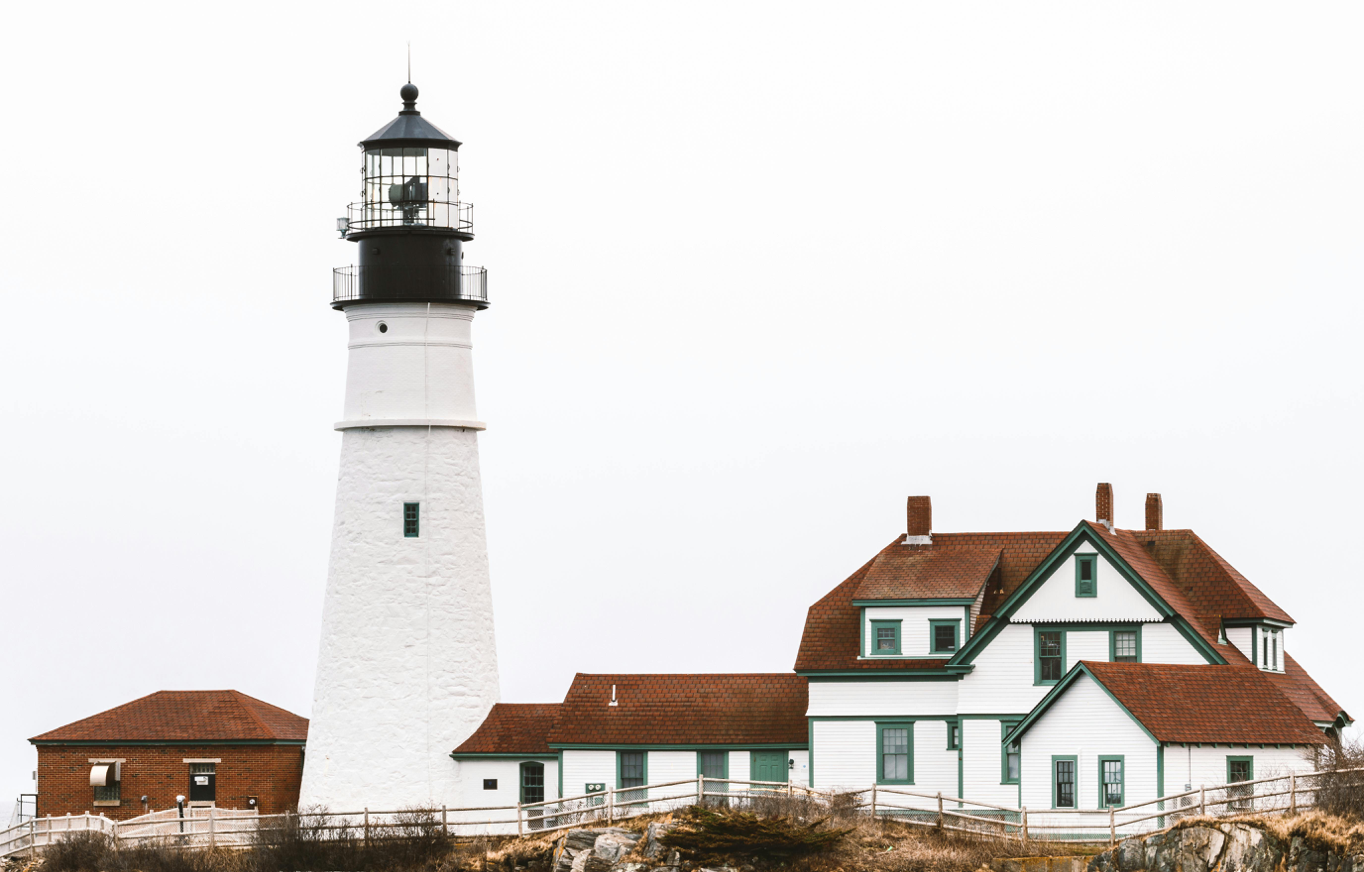 Picturesque view of Portland Head Light, a historic lighthouse on a rocky cliff in Cape Elizabeth, Maine.